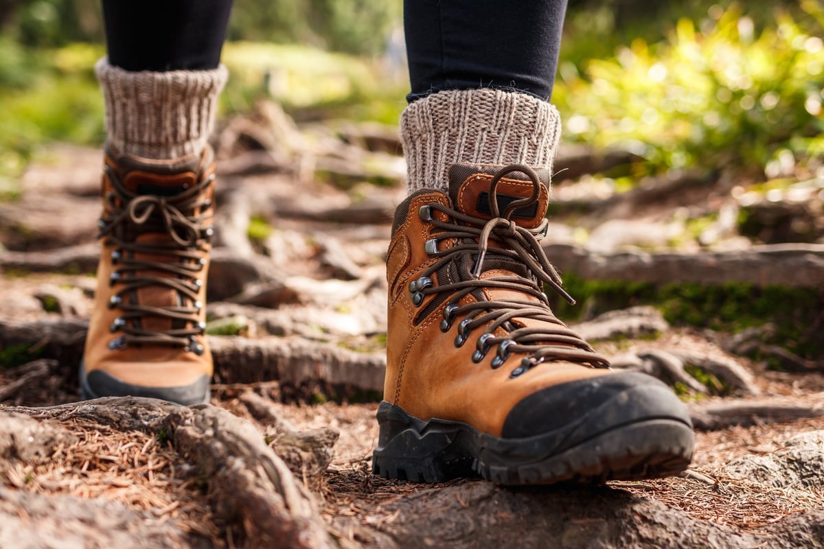 Hiker wearing boots on a mountain trail in the forest